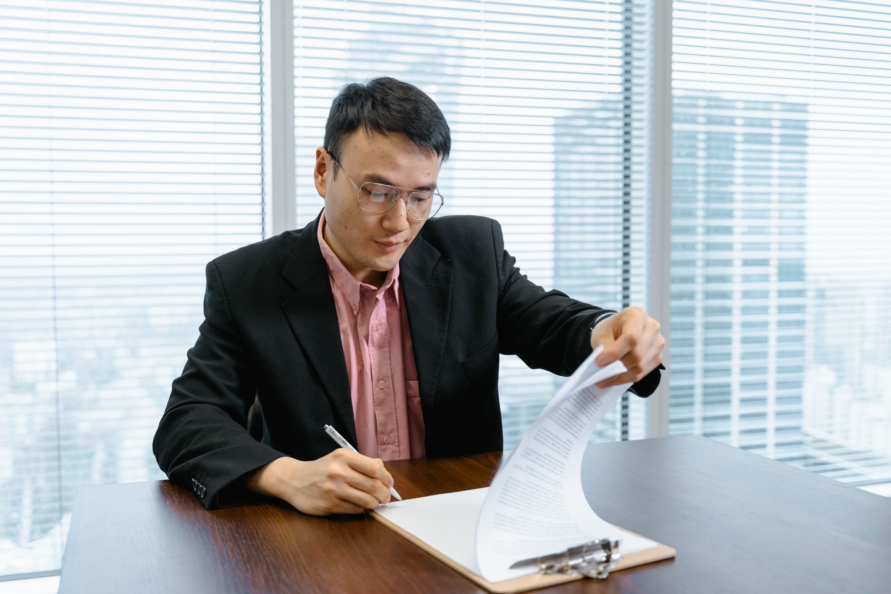 法人携帯の稟議書に署名するオフィスの様子